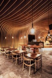 OOZN Design cover Indonesian cafe ceiling with undulating timber slats
