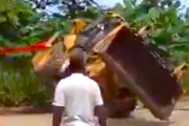 VIDEO: Backhoe takes bad bounce after being uprighted, is swallowed by jungle
