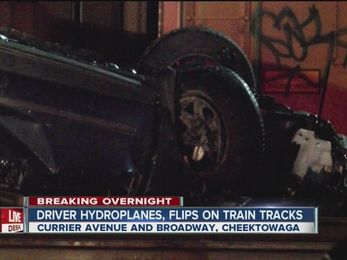Vehicle hydroplanes, flips and lands on railroad