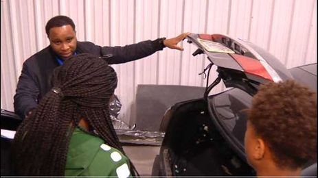 Local business owner teaching students basic automotive skills